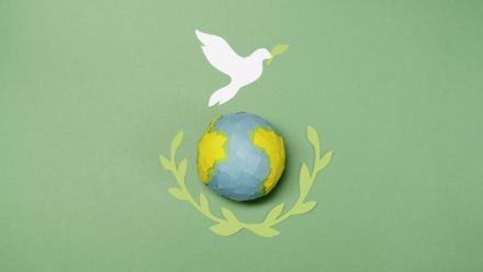 Artist impression of a peace dove flying above the globe and holding an olive branch